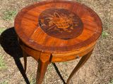a small wooden table with a carved design on it
