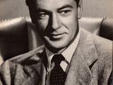 black and white photograph of a man in a suit and tie sitting in a chair