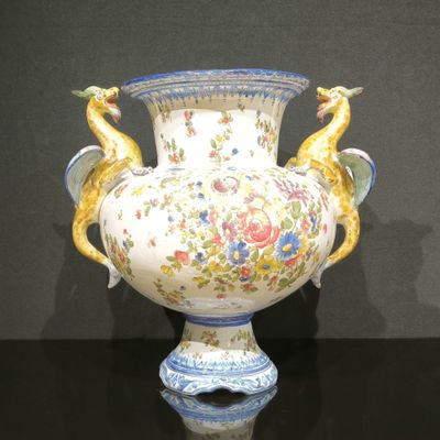 un vase orné de deux oiseaux, posé sur une table