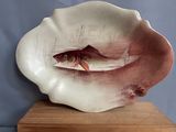 a fish in a shell on a wooden stand
