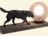 statue d'un chien tenant une balle dans la gueule, posée sur un socle