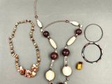 plusieurs colliers et bracelets différents disposés sur une table
