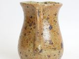a small vase with a brown glaze on it