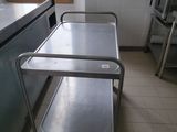a metal cart in the middle of a kitchen with a window