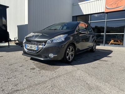 La voiture grise est garée devant un immeuble, sur un parking.
