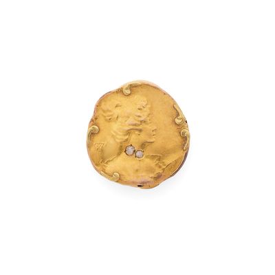 une vieille pièce d'or posée sur une surface blanche, avec un diamant au centre