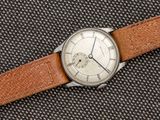 Gros plan sur une montre avec un bracelet en cuir marron