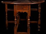 an old wooden table with a drawer underneath it on a black background