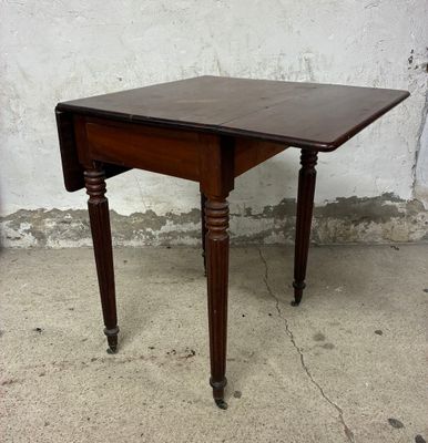 une petite table avec un plateau en bois sur un sol en béton