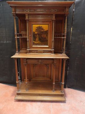 une vieille armoire en bois avec un tableau posé dessus