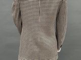 the back view of a mannequin wearing a black and white checkered blazer