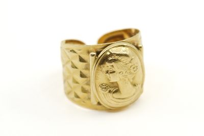 un gros plan d'une bague en or sur laquelle est gravé le visage d'une femme