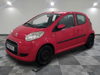 the small red car is parked in the garage on the checkered floor