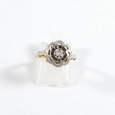 une photo d'une bague ornée d'une fleur en diamant et saphir