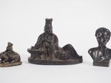 three bronze figurines of a man and a woman and a dog