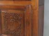 une vieille armoire en bois avec des sculptures et des gravures sur les portes