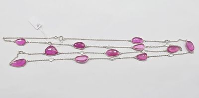 un gros plan d'un collier orné de pierres roses sur fond blanc