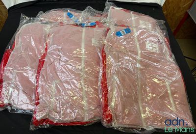 quatre morceaux de viande emballés dans du plastique, posés sur une table noire