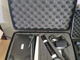 a black case with a microphone, a cell phone, and other items in it