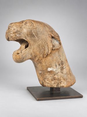 un gros plan sur une sculpture représentant une tête de lion la gueule ouverte