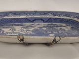 an old blue and white bowl with three hooks on it