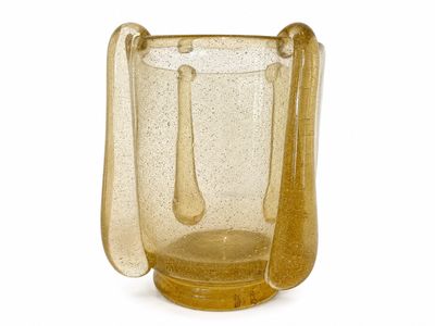 un vase en verre jaune contenant une cuillère