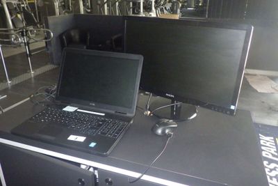 deux ordinateurs portables posés sur une table devant un écran d'ordinateur