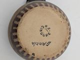 a brown vase with writing on it sitting on a table