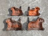 four antique cast iron animal bookends on a cement surface