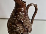 a brown pitcher sitting on top of a glass table