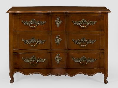 une commode ancienne dotée de poignées ouvragées et d'un plateau en bois