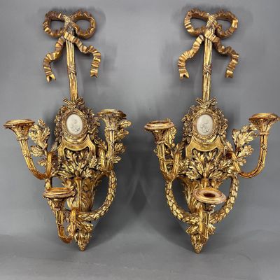 une paire d'appliques murales anciennes, chacune dotée d'une horloge