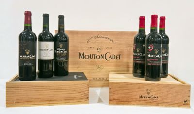 trois bouteilles de vin rouge dans un coffret en bois posé sur une surface blanche