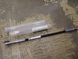 un stylo posé par terre à côté d'un tube