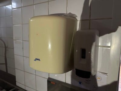 a paper towel dispenser and a paper towel dispenser in a bathroom