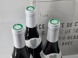 three bottles of wine sitting on a table next to a bag