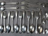 un grand nombre de cuillères et de fourchettes en argent disposées sur une table