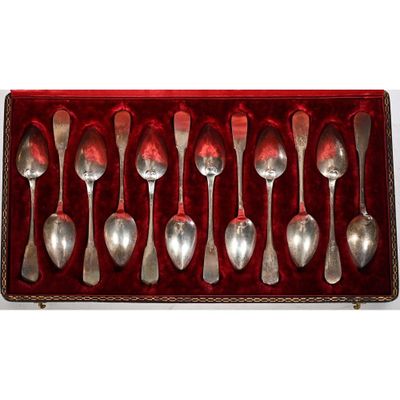 six cuillères dans un étui en velours rouge posé sur une surface blanche