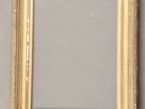 a gold picture frame on a gray wall
