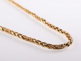 a close up of a gold chain on a white surface