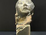 an image of a sculpture of a woman ' s face on a marble block