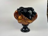 a black and gold bust of a man on a pedestal