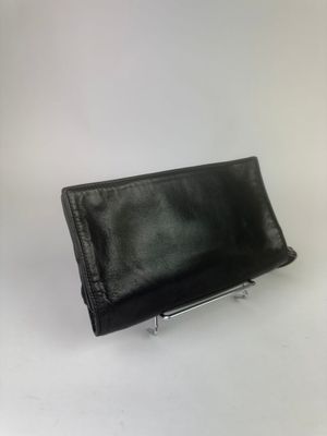 pochette en cuir noir avec armature métallique sur fond blanc