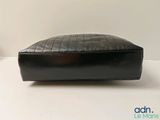 black leather poufce with a zipper on top of it on a white surface