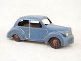 une petite voiture miniature posée sur une surface blanche