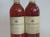 two bottles of wine sitting next to each other on a white surface
