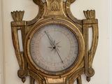 une horloge dorée accrochée au mur, dans un coin de la pièce