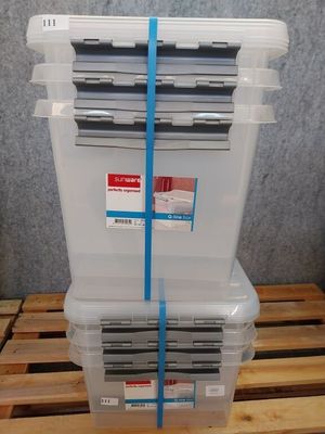 trois bacs en plastique avec couvercles, posés sur une palette