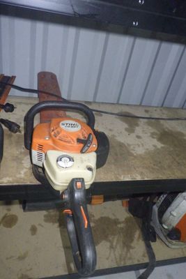 deux tronçonneuses posées sur un banc dans un garage