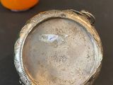a small silver bowl sitting next to an orange candle